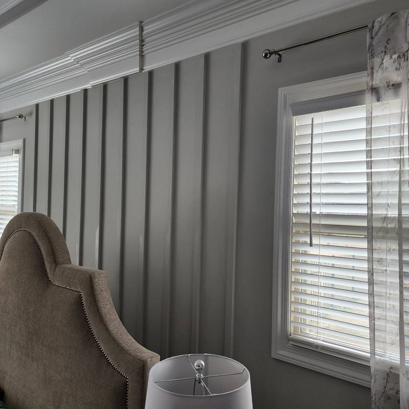 Board-and-batten accent wall with crown trim in a bedroom