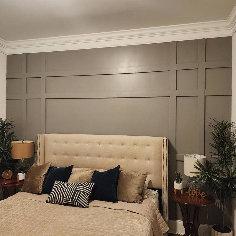 Painted grid-panel accent wall behind a bed