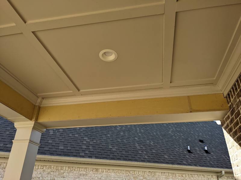 New roof shingles beyond a finished porch ceiling