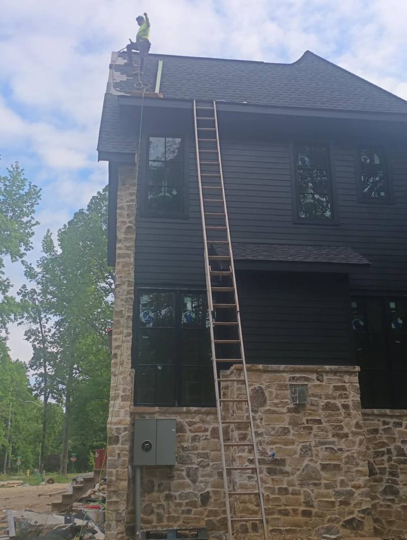 Exterior siding work on a tall home