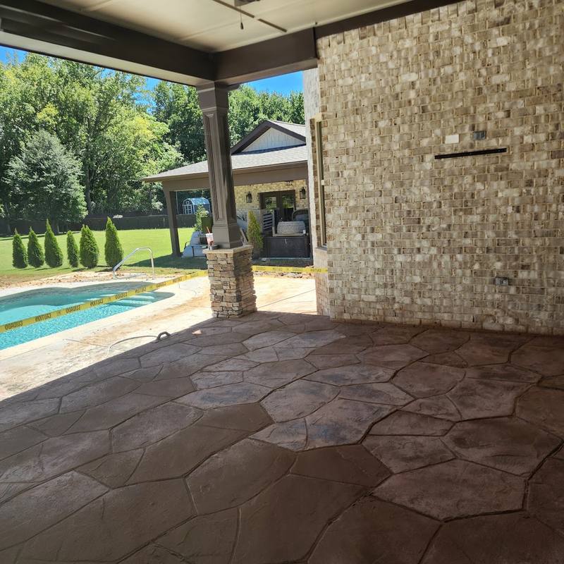 Concrete patio next to a backyard pool