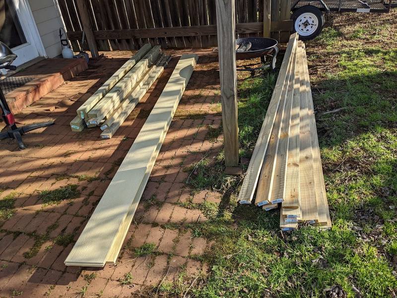 New lumber staged for a wood fence repair