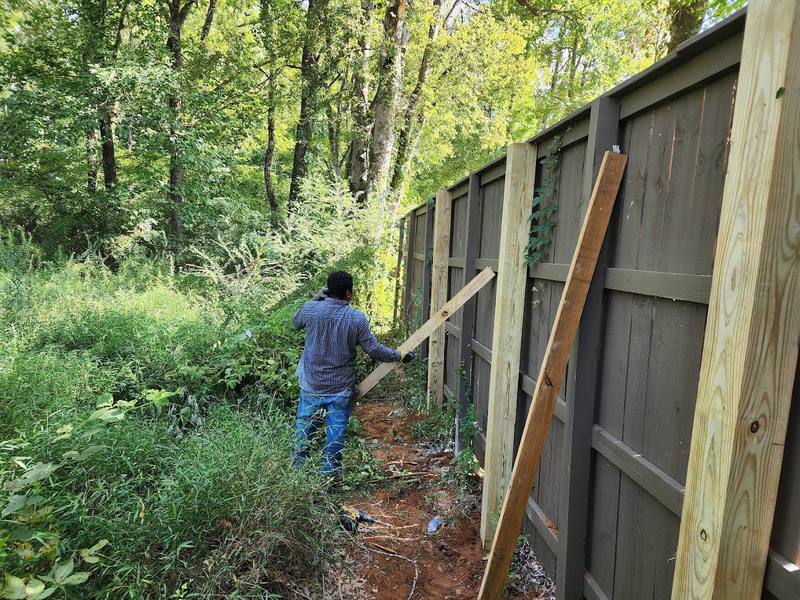 Wood fence repair with new posts installed